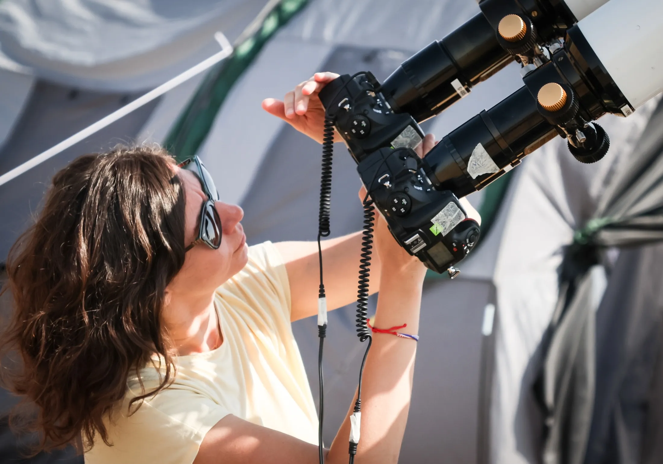 Researcher adjusting a camera rig in sunglasses