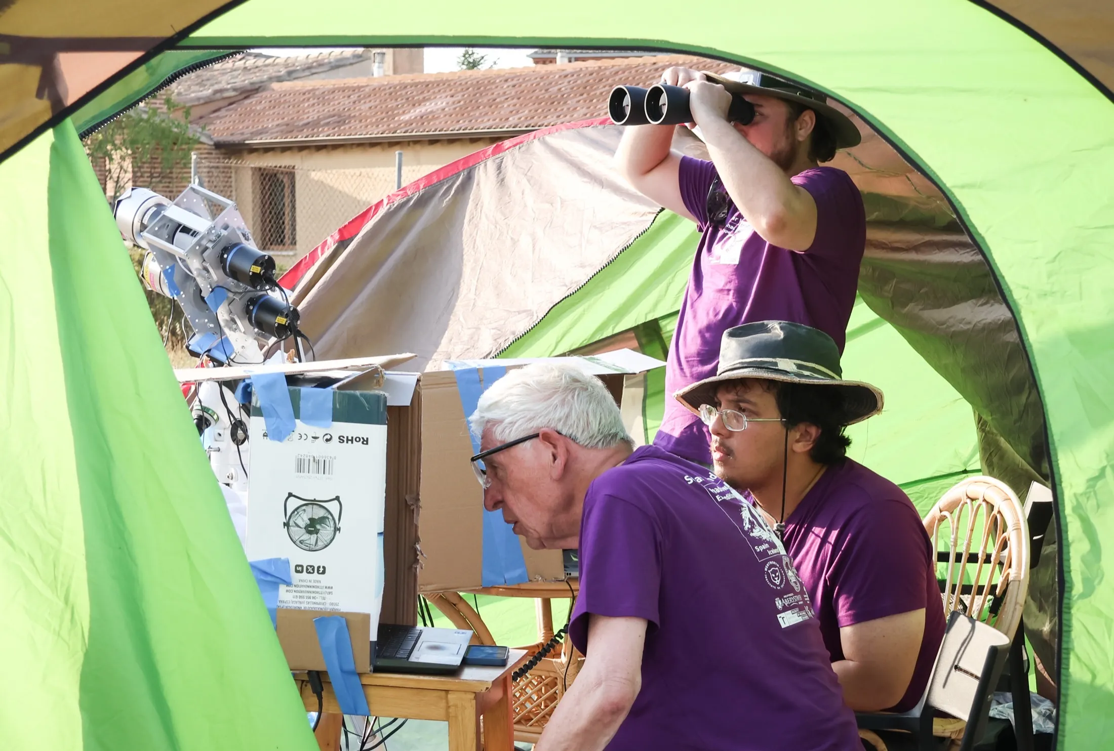 Inside a green dark tent with laptops and monitors
