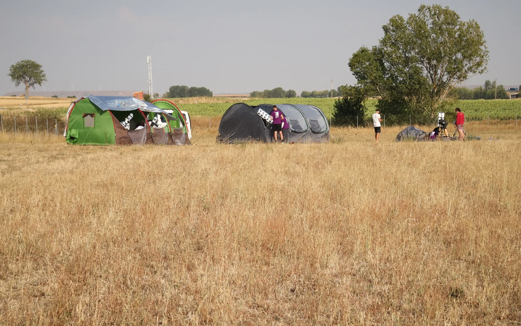 Wide view of the Padilla de Abajo observing site with tents and people