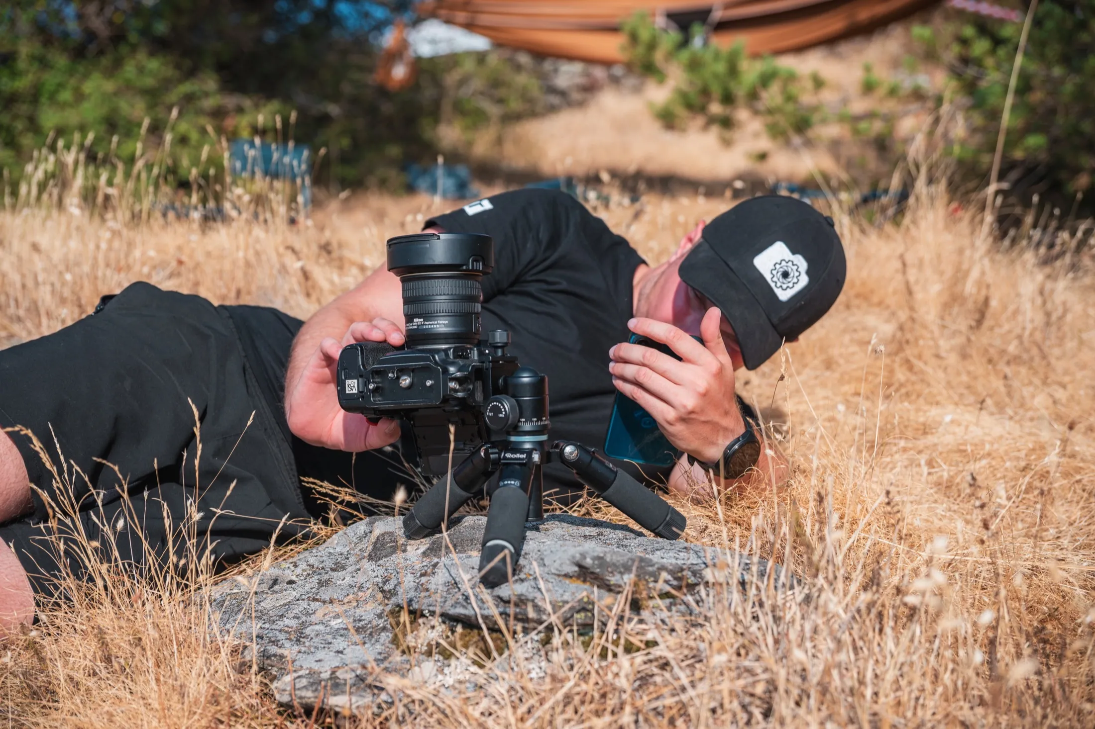 Researcher lying on the ground to calibrate a tripod-mounted camera