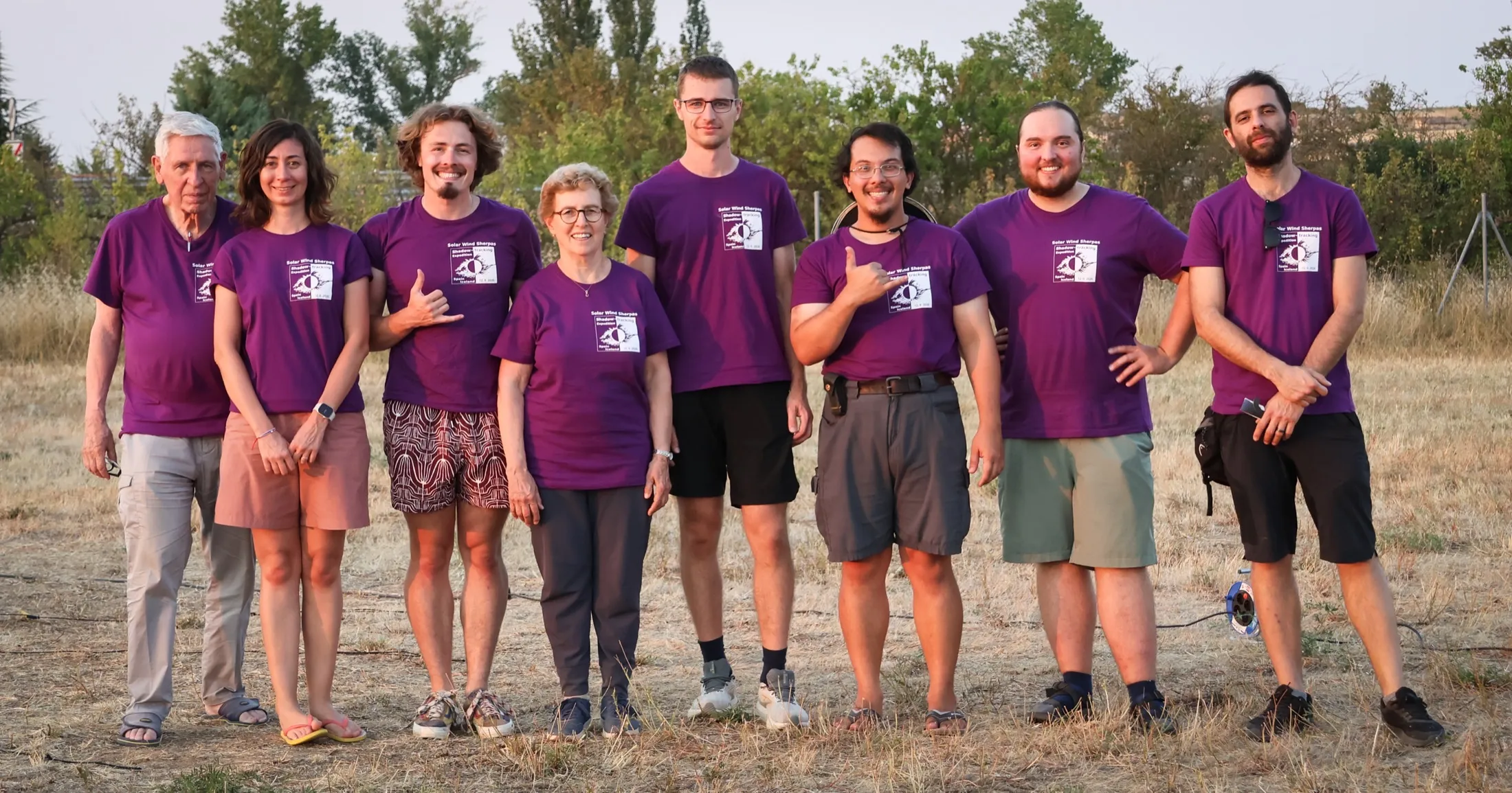 Seven Solar Wind Sherpas team members in purple shirts in a field