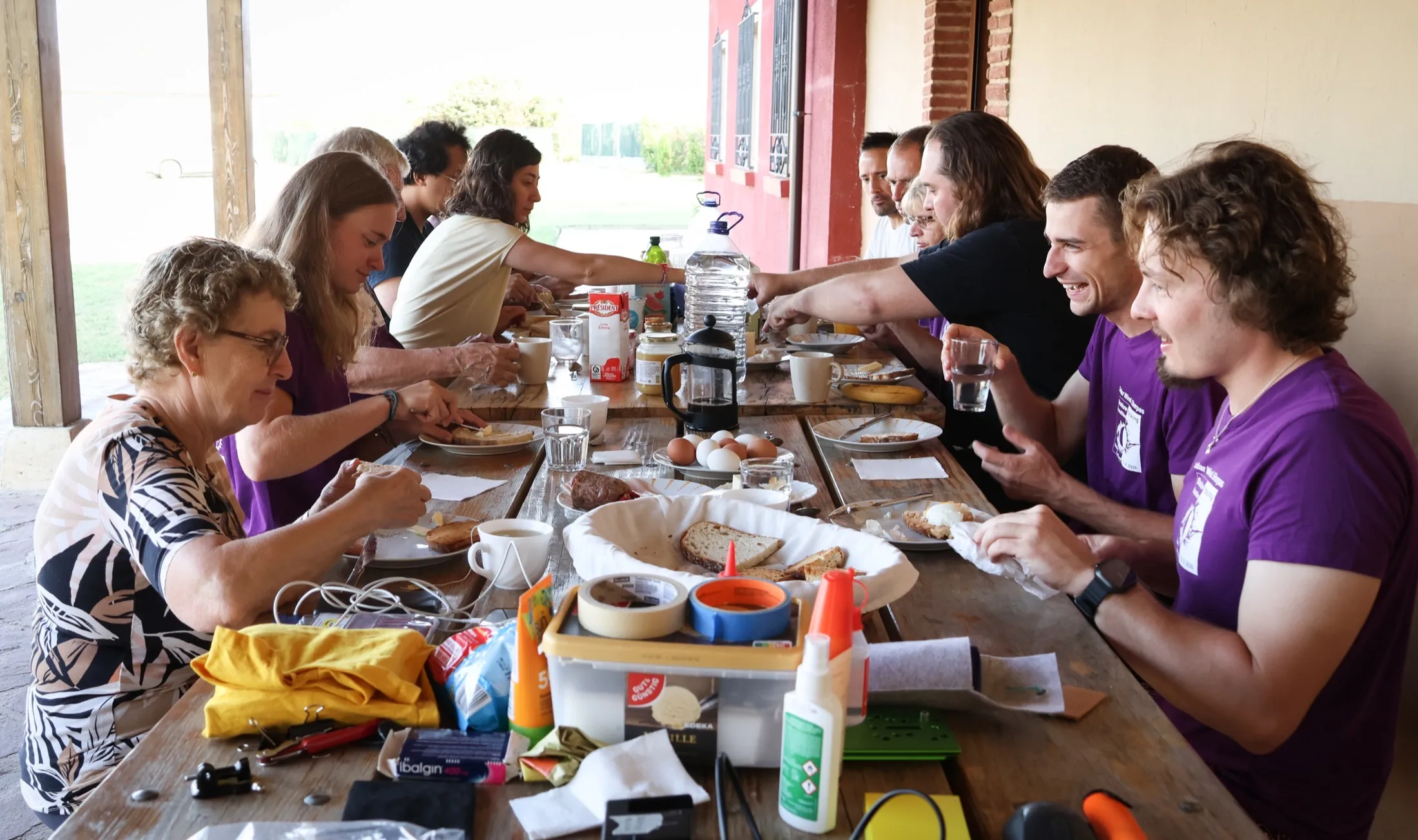 Team sharing a meal at a long outdoor table