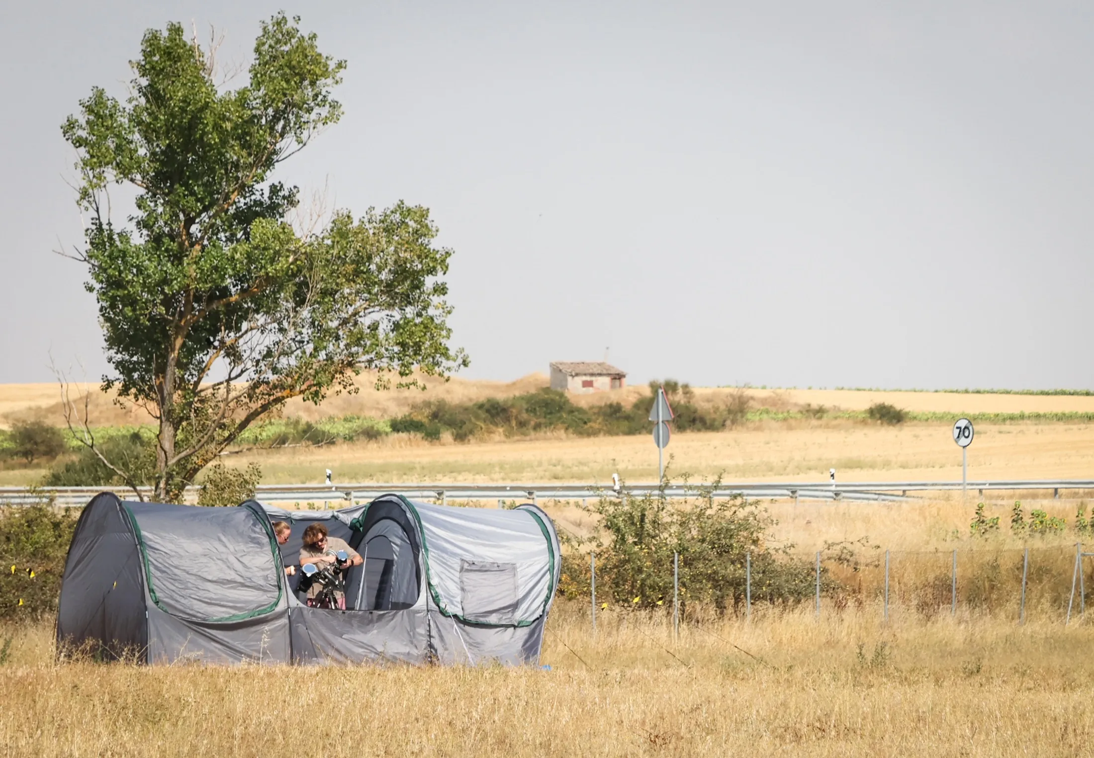 Wide shot of grey observation tents in a dry field