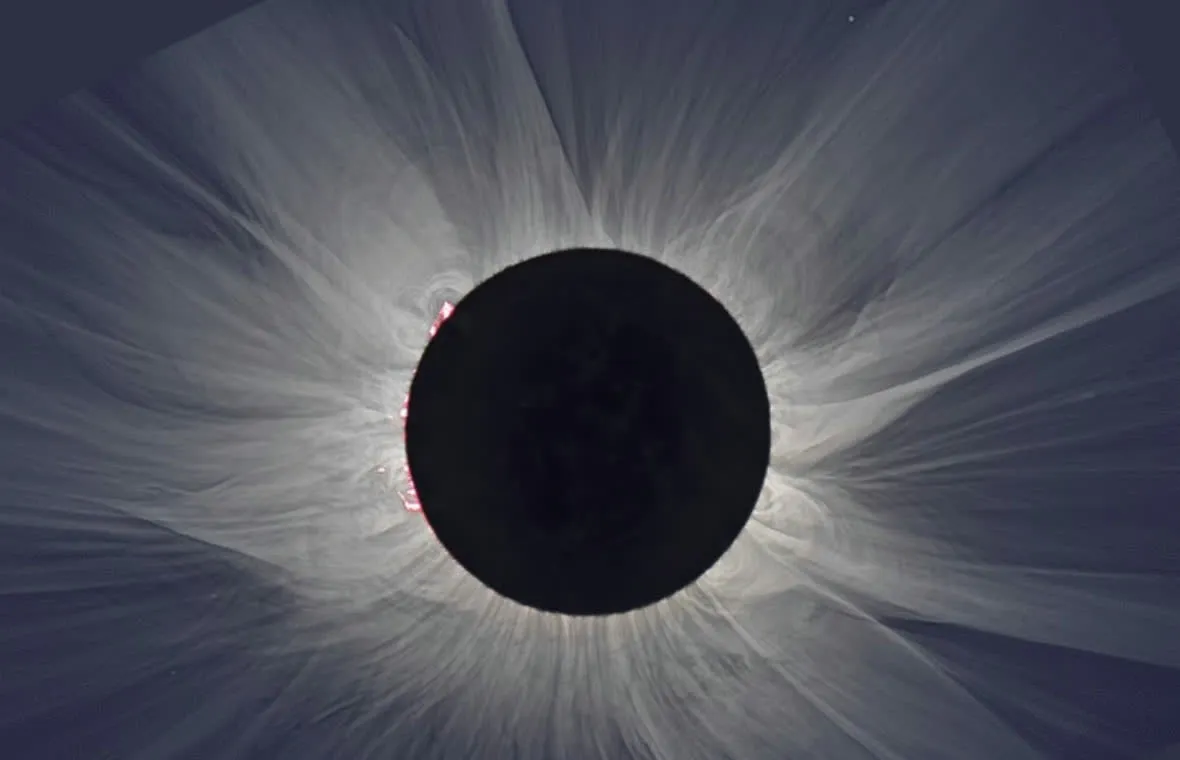 Processed white-light image of the solar corona during the total eclipse of 20 March 2015, with fine rays around the black disk of the Moon and a small prominence on the left