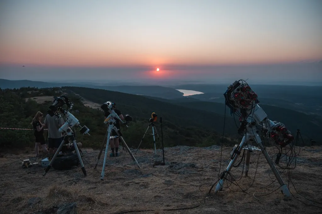 Telescopes set up on a ridge in Spain at sunset, ready for eclipse observations
