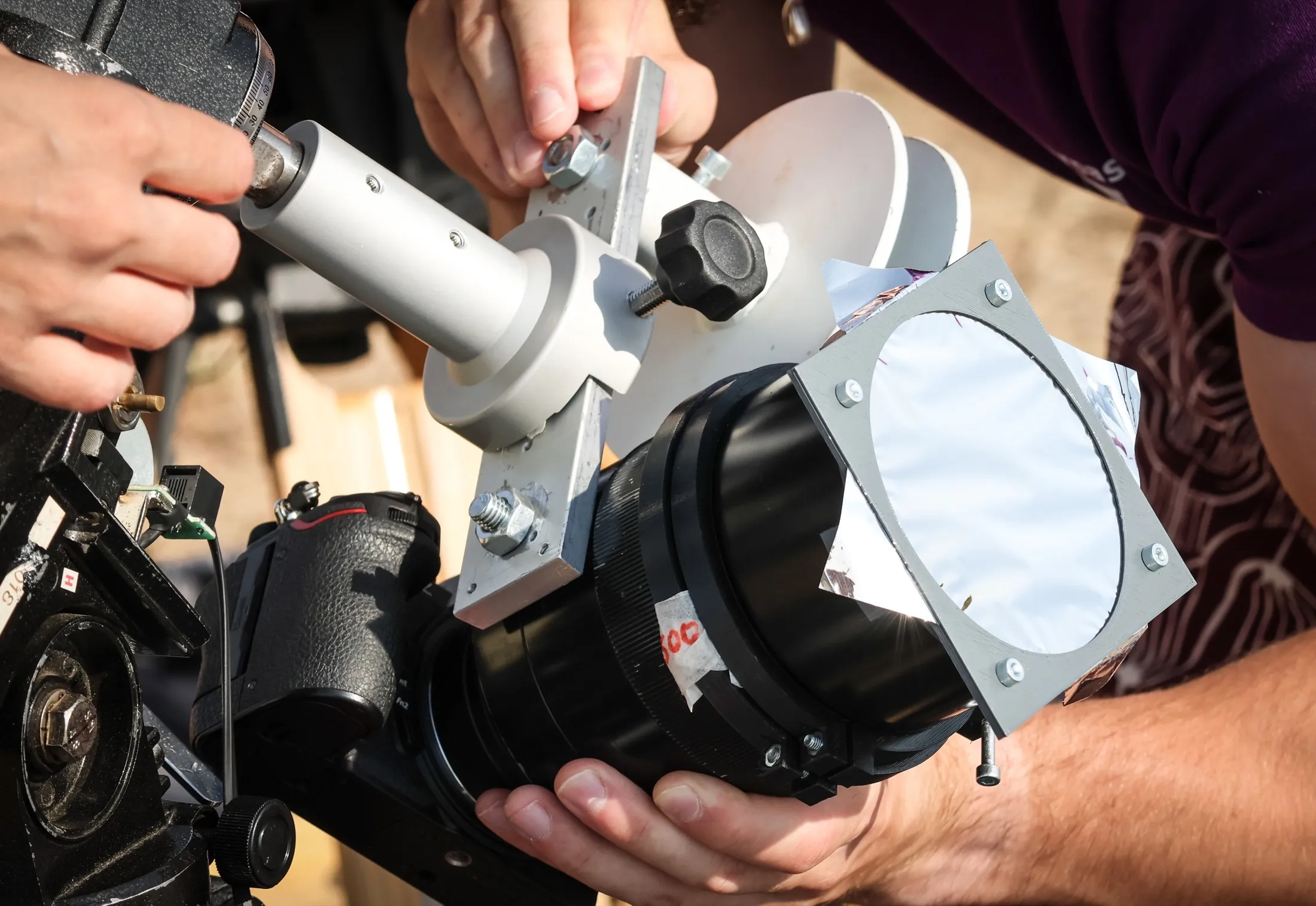 A researcher adjusting a large instrument mounted on a tripod
