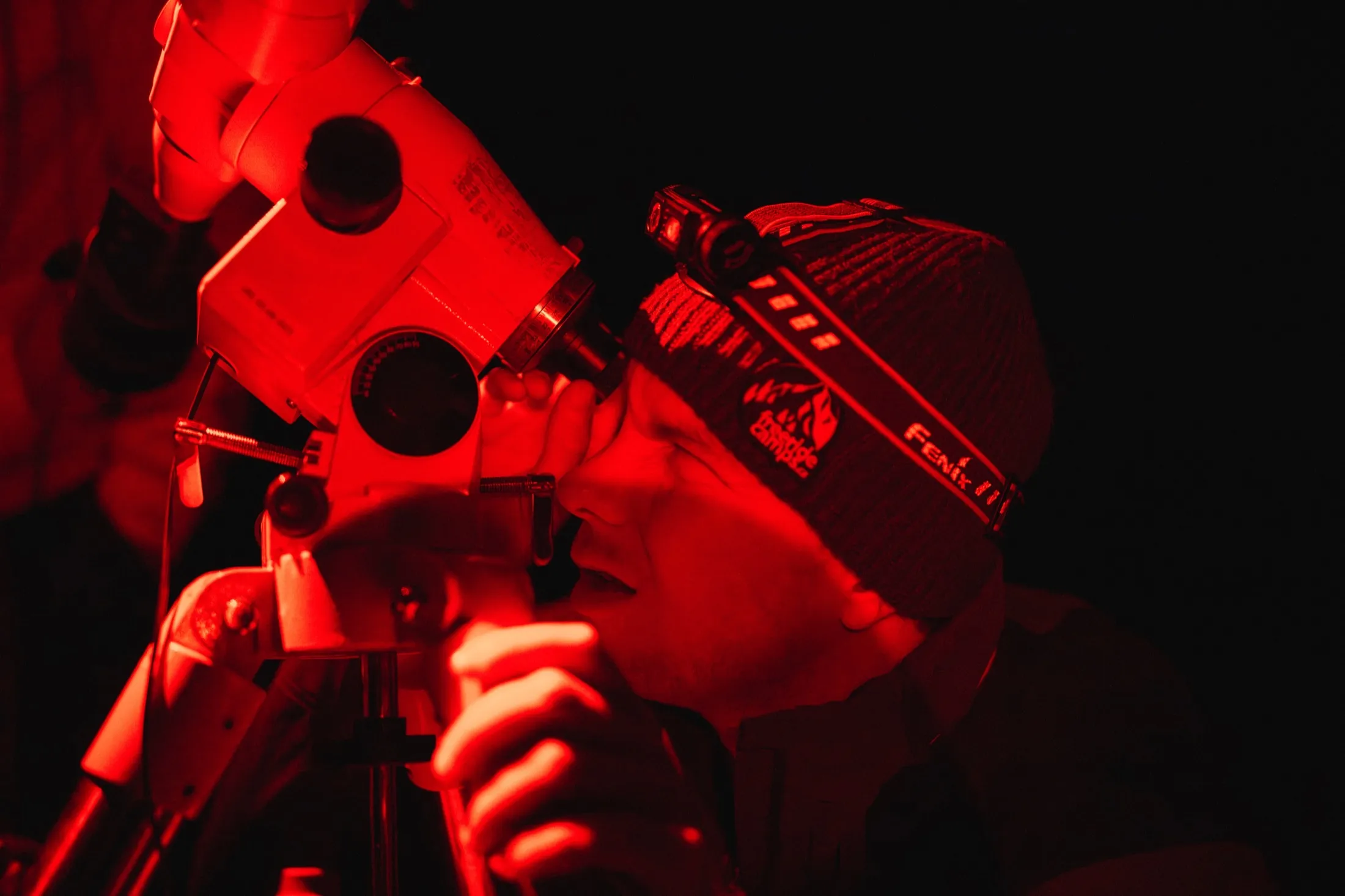 Researchers working on instruments at night under deep red light