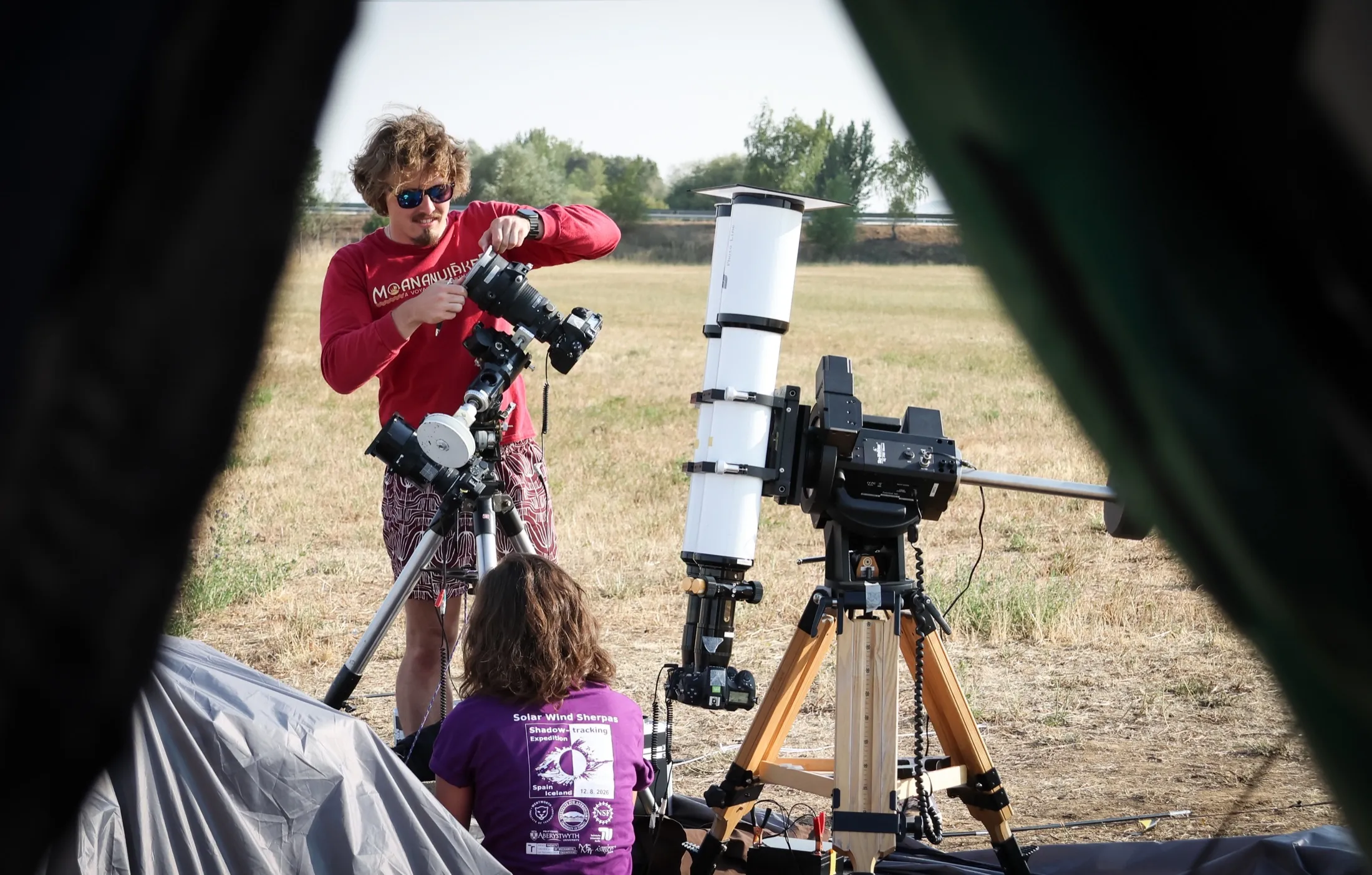 A researcher looking through a large white scientific instrument in the field
