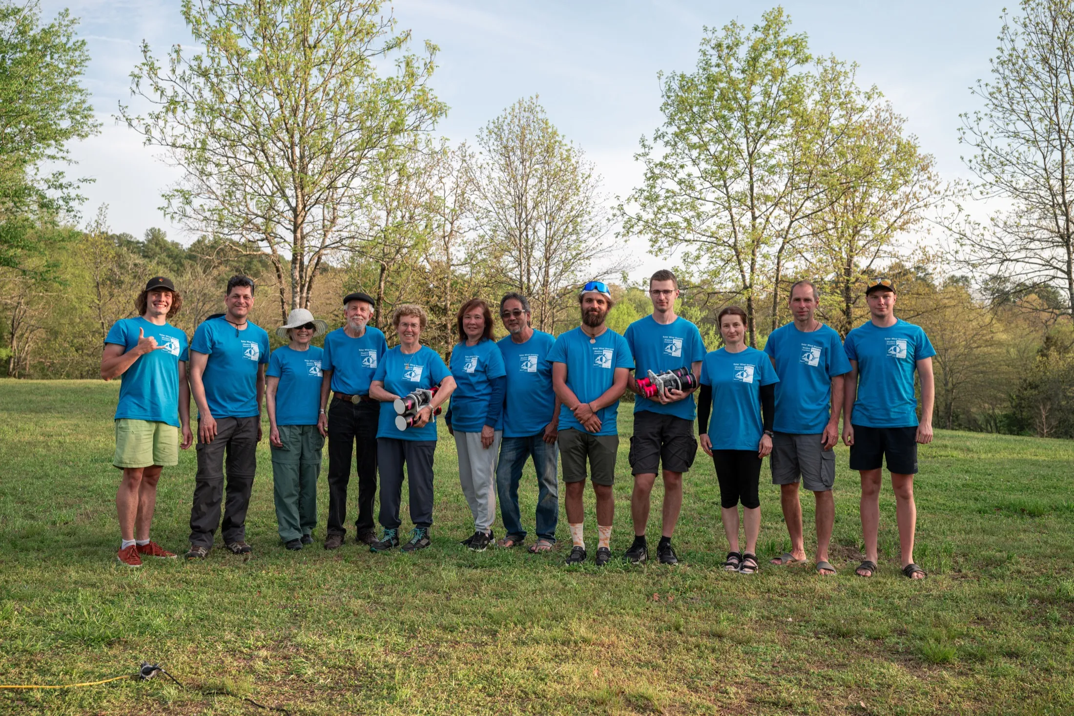 Solar Wind Sherpas team in matching blue shirts posing in a grassy field