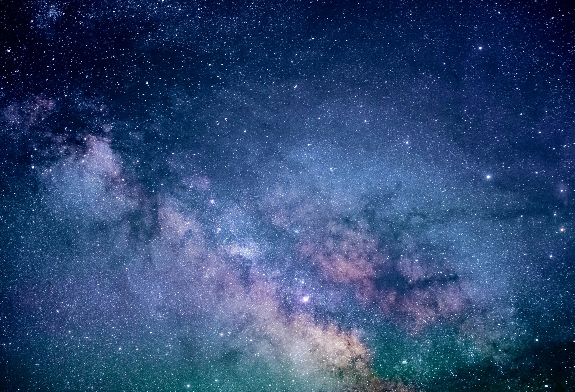 The Milky Way stretching across a dark night sky, dense with stars and dust lanes