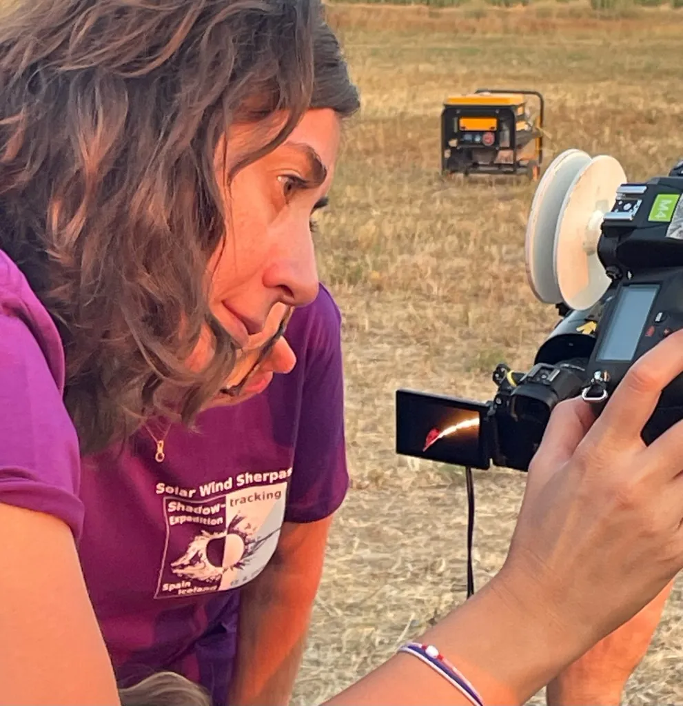 A Solar Wind Sherpas team member studies an eclipse image on a camera in the field